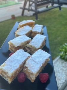 a plate of white desserts with raspberries on it at Vila PauDeea in Moisei