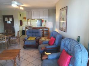 a living room with two blue chairs and a table at Laguna La Crete 94 in Margate