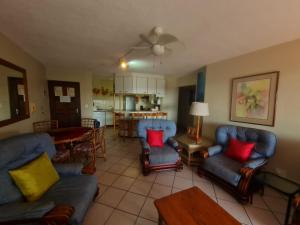 a living room with blue couches and a kitchen at Laguna La Crete 94 in Margate