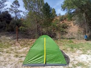 una tenda verde in un campo vicino a una recinzione di El Rebost de Penyagalera a Beceite