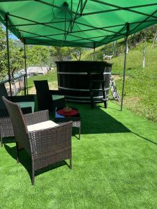 een patio met stoelen en een groene parasol bij Vila PauDeea in Moisei