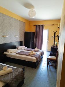 una habitación de hotel con 2 camas y una silla en Vosporos Hotel, en Komotiní