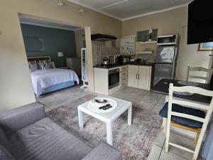 a kitchen and living room with a bed and a table at Senelle accomodation in Hermanus