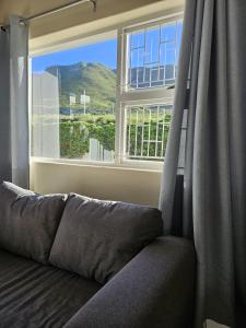 a couch in a room with a large window at Senelle accomodation in Hermanus