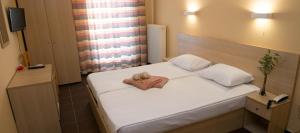 a bedroom with a bed with a towel on it at Vosporos Hotel in Komotini +18 photos
