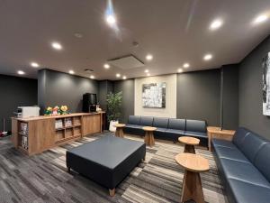 ein Wartezimmer mit blauen Sofas und Tischen in der Unterkunft Hotel Route-Inn Toyama Ekimae in Toyama