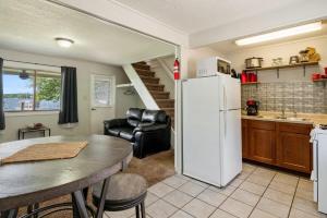 a kitchen with a table and a white refrigerator at Fife Lake Lodge 2BR Loft with Kitchen & Lake Views in Fife Lake