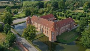 - une vue aérienne sur un grand bâtiment en briques avec une réflexion dans l'établissement Hotel Møllehuset, à Hadsund