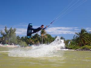 um homem está no ar sobre um corpo de água em Ikarus kiteboarding em Ilha das Mulheres