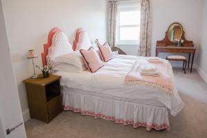 um quarto com uma cama grande e almofadas cor-de-rosa em Southsea, Portsmouth - Two Bedroom Apartment - Newly Refurbished Throughout - Treetop Sea Views em Portsmouth