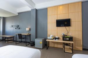 a bedroom with a bed and a tv on a wall at Riverview Residence in Bangkok