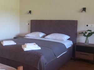 Rustic village في رييكا تسرنوييفتشا: غرفة نوم بسرير كبير عليها مناشف