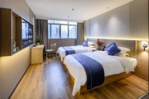 pokój hotelowy z 2 łóżkami i telewizorem w obiekcie Shanshui S Hotel w Guangzhou
