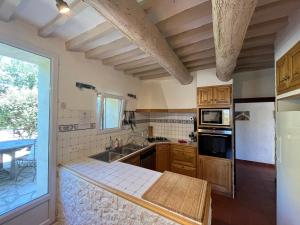 a kitchen with wooden cabinets and a counter top at Mas Côté Cour in Maubec