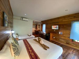 a bedroom with a large white bed and wooden walls at Coconut Lanta Resort @Klong Dow beach in Krabi