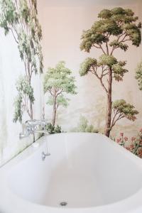 a bath tub in a bathroom with trees on the wall at Southsea, Portsmouth - Two Bedroom Apartment - Newly Refurbished Throughout - Treetop Sea Views in Portsmouth