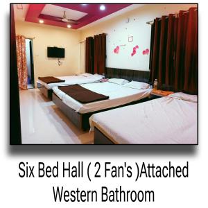 a bedroom with three beds in a room with a tv at Palange Bhakt Niwas in Tuljapur