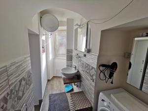 uma casa de banho com um lavatório, um espelho e uma máquina de lavar roupa em Two Rooms Bellini em Catânia