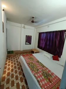 a bedroom with a large bed with a red blanket on it at Green stay homestay in Rāmnagar
