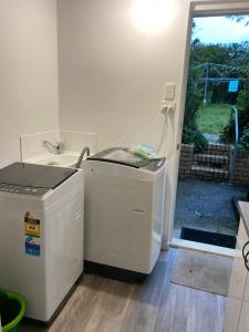 a kitchen with a washer and dryer next to a door at YnY Guest house in Waterford