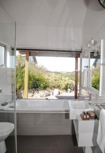 Baño blanco con bañera y lavamanos en Anchors Port Campbell, en Port Campbell