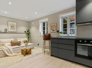 Una sala de estar con un sofá y una cocina. en Stay l The Town House, en Bergen