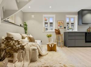 Una sala de estar con un sofá y una cocina. en Stay l The Town House, en Bergen