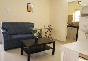 a living room with a couch and a table with flowers at HOTEL ROYAL SUITES AND ROOMS Near AIG Hospital Gachibowli in Gachibowli