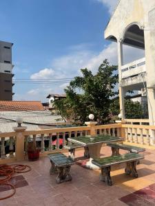 patio z dwoma stołami piknikowymi i ogrodzeniem w obiekcie Saysouly Guest House w mieście Ban Nongdouang