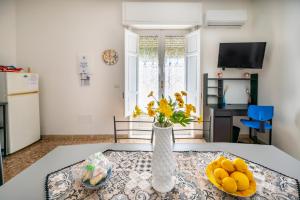 a living room with a table with a vase of flowers at Casa Nonna Paola in Siracusa