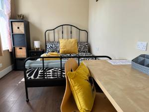 a bedroom with a bed with a wooden table at Rectory Cottage in Croydon