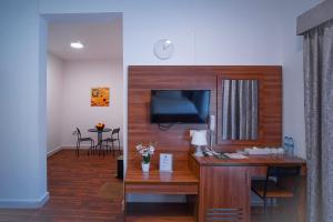 un soggiorno con scrivania, TV e tavolo di AL KARNAK HOTEL - BRANCH a Dubai