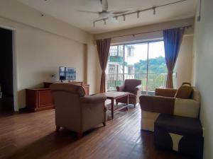 a living room with a couch and chairs and a television at The Little Star Hotel & Studio at Star Regency Residence in Brinchang