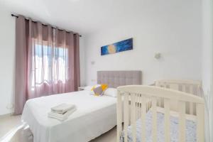 1 dormitorio con cama blanca y cuna en Casa Las Calas, en Torrevieja