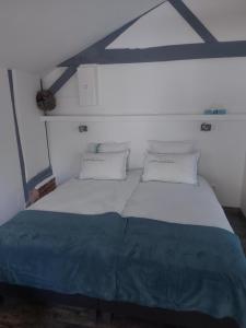 a bedroom with a large bed with two pillows at Gîte, Le Séchoir à Lin demeure de charme in Veauville-les-Baons