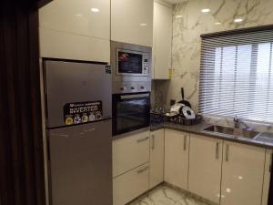 uma cozinha com um frigorífico e um lavatório em Luxurious 2 Bedroom Penthouse For Rent em Rawalpindi