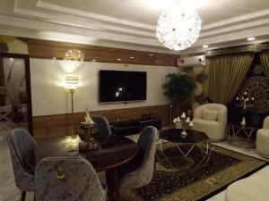 uma sala de estar com uma televisão e uma mesa e cadeiras em Luxurious 2 Bedroom Penthouse For Rent em Rawalpindi