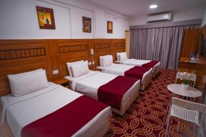 AL KARNAK HOTEL - BRANCH في دبي: غرفه بالفندق ثلاث اسره وطاولة