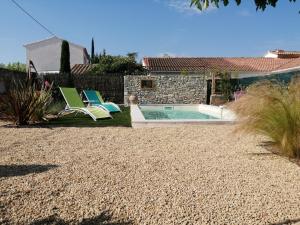 un patio trasero con 2 sillas y una piscina en La maison du petit écolier, en LʼIsle-sur-la-Sorgue