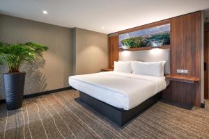 um quarto com uma cama grande e um vaso de plantas em Sky Loft Hotel Kyiv by Rixwell International em Kiev