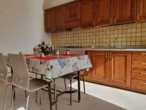 eine Küche mit einem Tisch mit Stühlen und einem Waschbecken in der Unterkunft Heron House Apartments in Agnone Bagni