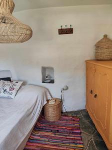 a bedroom with a bed and a dresser and a rug at Sifnos Twin Houses in Apollonia