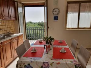 einen Esstisch mit roten Servietten und einer Uhr in der Unterkunft Heron House Apartments in Agnone Bagni