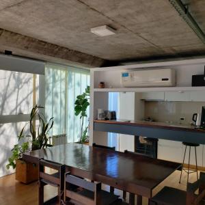 a dining room with a table and a kitchen at Dos Porticos - Tecnologia y naturaleza in La Plata