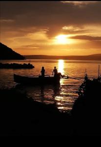 twee mensen in een boot op het water bij zonsondergang bij Appartamento Gargano in Carpino