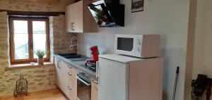 una pequeña cocina con microondas y nevera. en Ô JOLi BUGEY en Saint-Rambert-en-Bugey