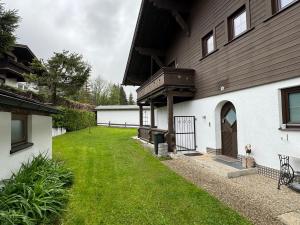 a house with a grass yard next to a building at Appartement Zugspitze 2 in Ehrwald