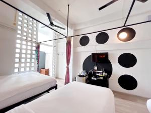 a bedroom with two beds and a desk in it at Riverview Residence in Bangkok