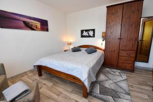 a bedroom with a bed and a wooden cabinet at Haus "Luv und Lee" Appartement LEE15 in Döse +11 photos