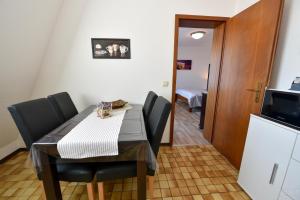 een eetkamer met een tafel en stoelen en een magnetron bij Haus "Luv und Lee" Appartement LEE15 in Döse